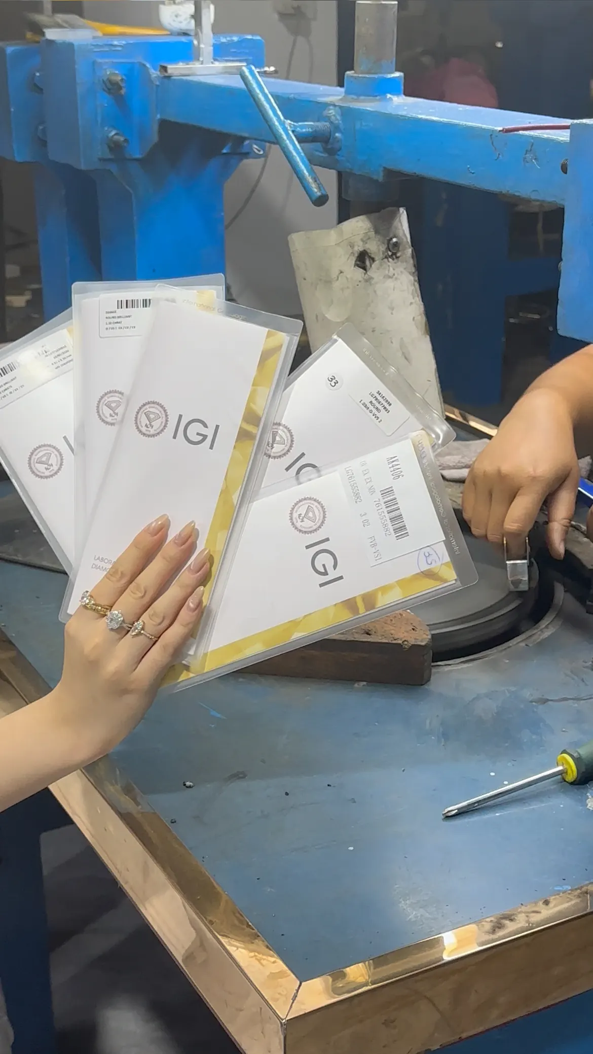 IGI report documents being reviewed at a jewelry workbench.