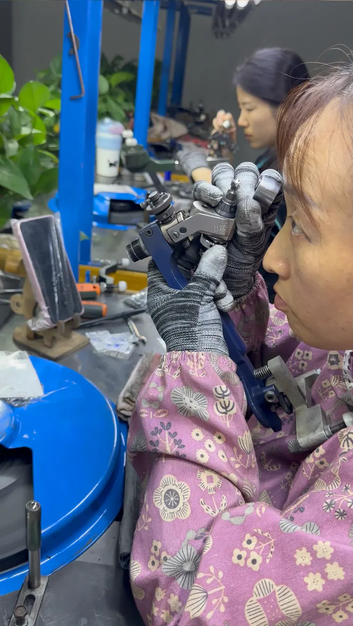 Jewelry craftsperson inspecting a piece at a workbench.