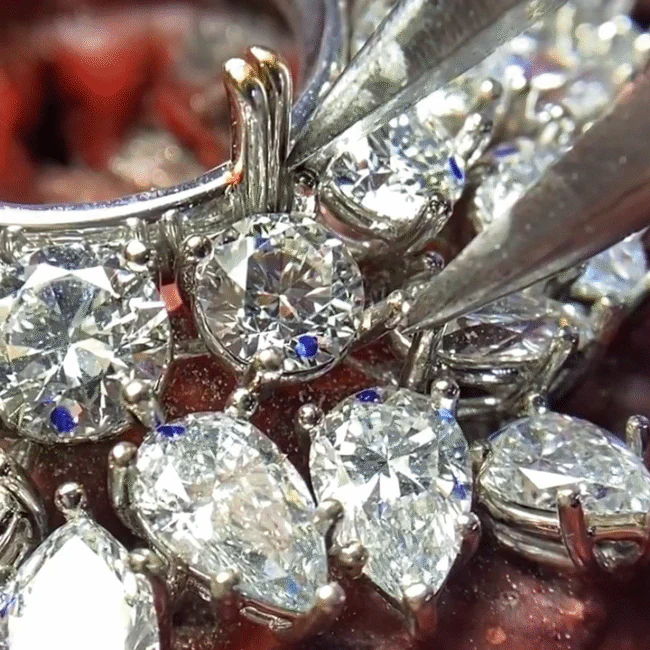 Close-up view of diamonds being secured in a jewelry setting